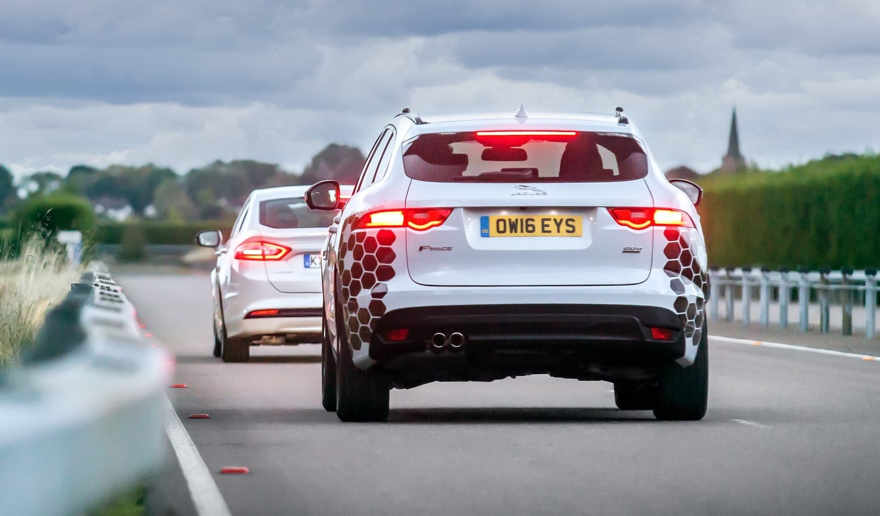 A Jaguar F-Pace SUV, photographed from the rear with its brake lights illuminated