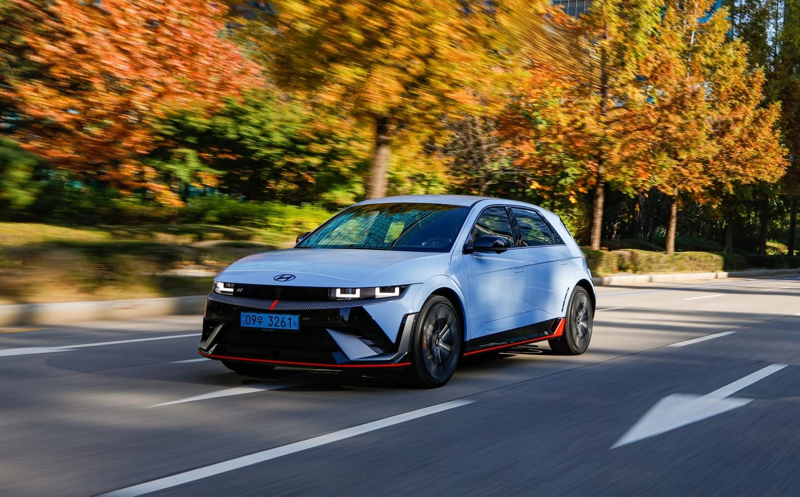 A Hyundai Ioniq 5 N being driven on a leafy road, photographed from the front three-quarters angle