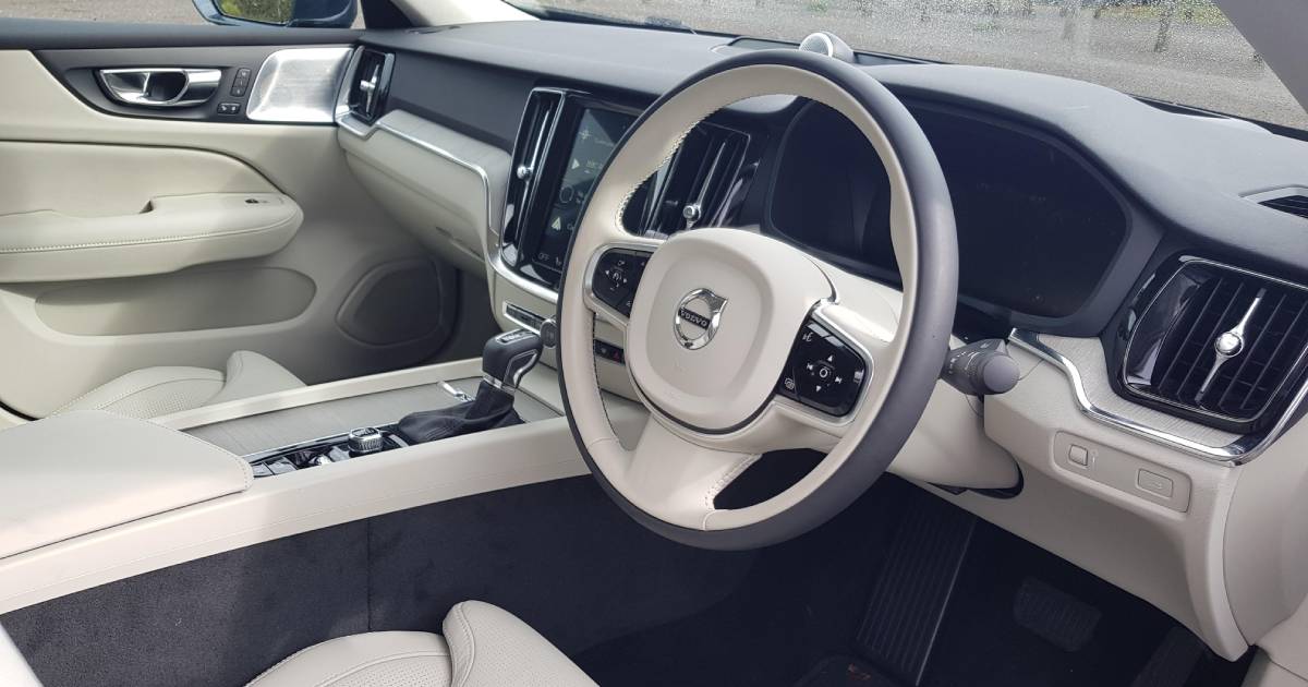 An Ivory coloured Volvo S60 interior, shot from the open driver's door